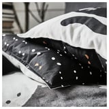 Funda de almohada con temática de gato con manchas en una superficie acolchada.