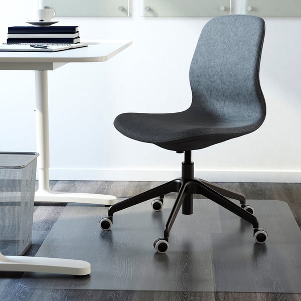 Silla de oficina gris con altura, inclinación y soporte lumbar, que se muestra debajo de un escritorio con libros.