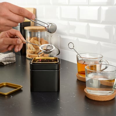 Persona que usa el infusor de té LINDÅDRA para preparar té en una taza.