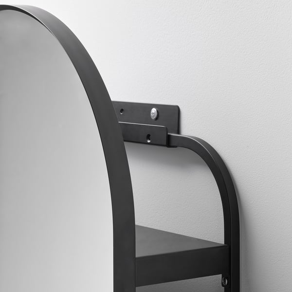 Estante de pared metálico montado con tornillos y brazos de soporte visibles, fijado a la pared de color claro.