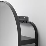 Estante de pared metálico montado con tornillos y brazos de soporte visibles, fijado a la pared de color claro.