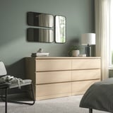 Dormitorio moderno con tocador LINDBYN, ropa de cama gris y espejo negro.