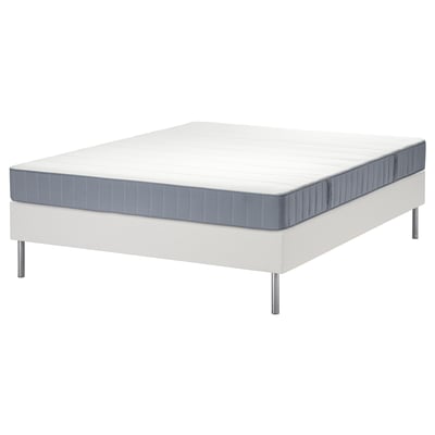 Estructura de cama LYNGÖR blanca con colchón azul grisáceo. La base tiene patas metálicas delgadas y listones planos.