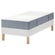 Cama blanca moderna con colchón azul, patas de madera, diseño minimalista.