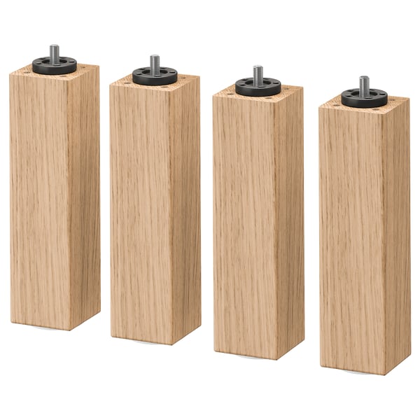 Cuatro patas de muebles de madera marrón claro con accesorios de metal negro en la parte superior.