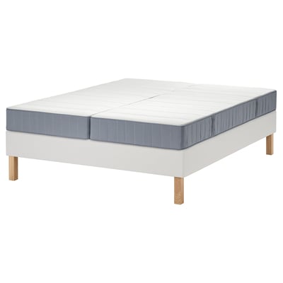 Somier LYNGÖR blanco con laterales azules, patas de madera y colchón blanco.