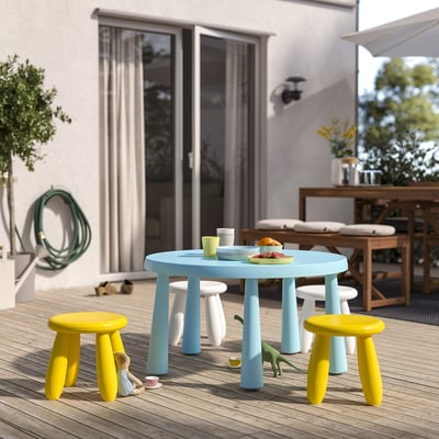 Mesa infantil azul con taburetes de dinosaurio amarillos, uso interior/exterior.