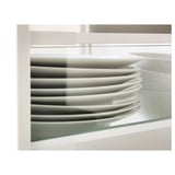 Platos blancos apilados dentro de un cajón con lados de vidrio, mostrando claridad organizativa y evitando que los artículos sobresalgan.