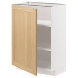 Mueble de cocina METOD con puerta de madera clara y marco blanco, parcialmente abierto.