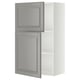 Un mueble de cocina METOD con puertas de bodbyn gris y marco blanco, con bordes biselados y estantes ajustables.