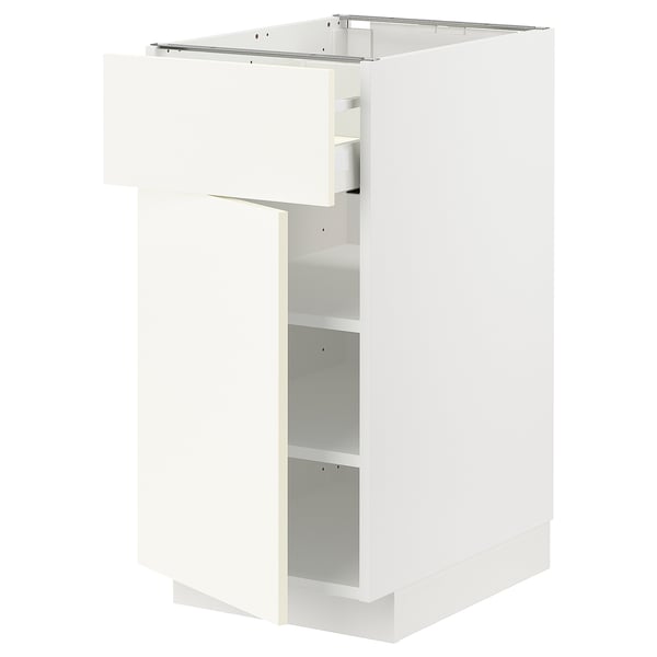 Un mueble de cocina METOD blanco con una puerta abierta, que revela un interior vacío y estantes ajustables.