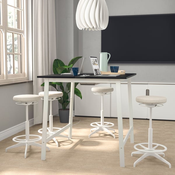 Moderna configuración de oficina blanca MITTZON con cuatro taburetes blancos, elegante mesa negra y lámpara de moda, espaciosa y elegante.