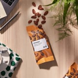 Almendras de IKEA en el escritorio con portátil, bolígrafo, planta