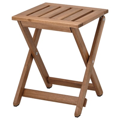 Esta imagen muestra un taburete de madera NÄMMARÖ de ikea, de color marrón, de forma cuadrada, plegable con un diseño sencillo y resistente.