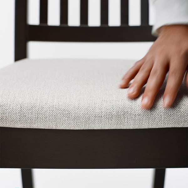 Primer plano de la silla NÄSINGE, que muestra un asiento suave y acolchado y una estructura de madera robusta, que destaca la calidad y la comodidad.