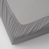 Sábana bajera gris con bordes elásticos, diseñada para adaptarse a colchones de hasta 26 cm de grosor. Confeccionado en 100% algodón para mayor comodidad y transpirabilidad.