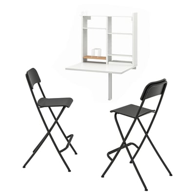 Mesa abatible de pared con almacenamiento y 2 taburetes negros, estantes organizados.