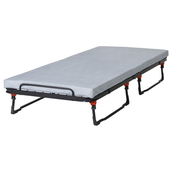 Una cama de invitados NORRUDDEN gris plegada con estructura y acolchado de metal, diseñada para un fácil almacenamiento y uso.