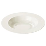 La placa profunda OFANTLIGT es blanca, está hecha de porcelana duradera y tiene un diseño de borde redondeado y texturizado.