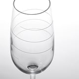 Primer plano en blanco y negro de una copa de vino vacía con intrincadas líneas de diseño, que resaltan su claridad cristalina y su elegante tallo.