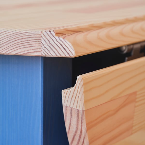 Primer plano de un borde de mesa de madera robusto y bien acabado. La veta lisa de la madera y las juntas limpias indican una artesanía de alta calidad.