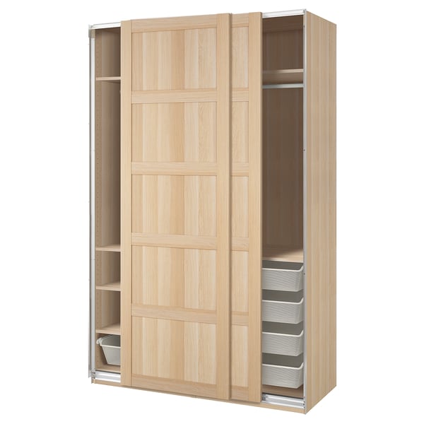 Armario moderno de madera clara IKEA PAX con puertas correderas y cestas de malla blanca.