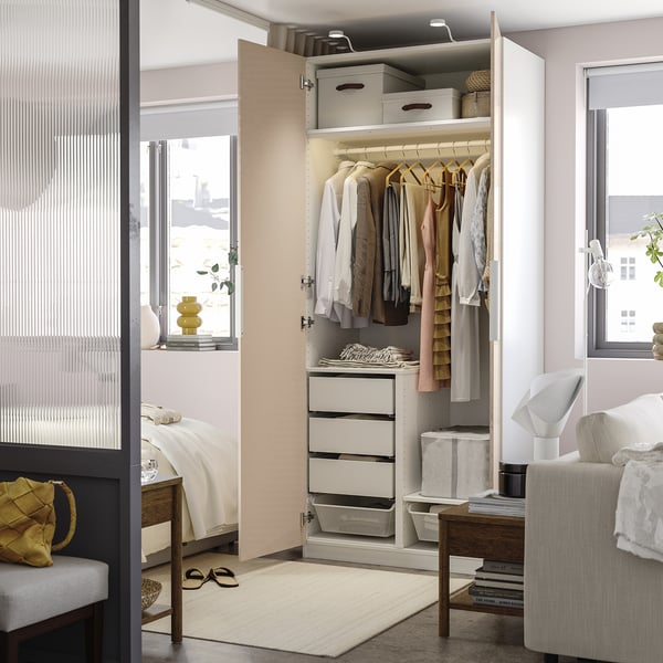 Armario cerrado con ropa, cajones y estantes. Cajas superiores para almacenamiento. Cuelga camisas, pantalones y vestidos.