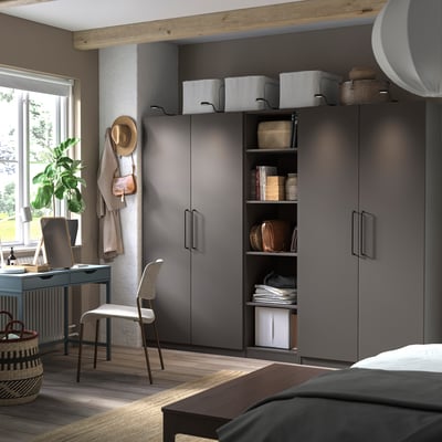 Dormitorio moderno con armario PAX gris, estanterías, escritorio y silla.