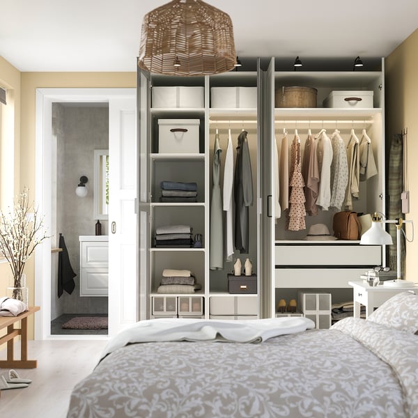 Un armario PAX con puertas con espejos. En el interior, tiene estantes, barras para colgar ropa y cajones con organizadores. También hay iluminación ajustable.