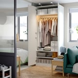 Armario de dormitorio moderno con ropa, estanterías e iluminación interna. Puertas de cierre suave y almacenamiento organizado.