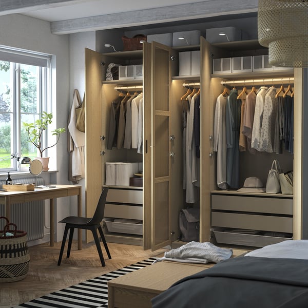 Armario moderno con puertas abiertas que muestra ropa organizada, como camisas, pantalones y accesorios. Cuenta con estanterías regulables e iluminación interior.