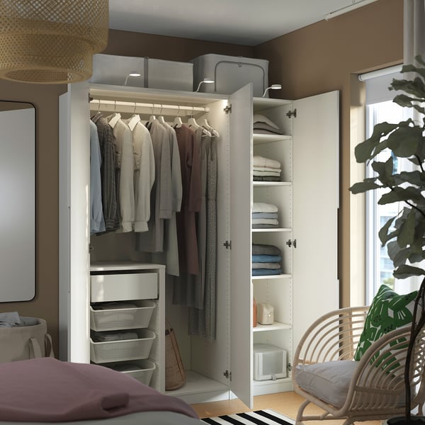 Dormitorio moderno con armario PAX, ropa cuidada y accesorios. Silla y planta de mimbre.