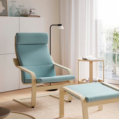 Silla y reposiebre azul claro POÄNG. Diseños modernos y cómodos con madera curvada y pana blanda. La silla y el reposapiés son más grandes comparados con la mesita auxiliar.