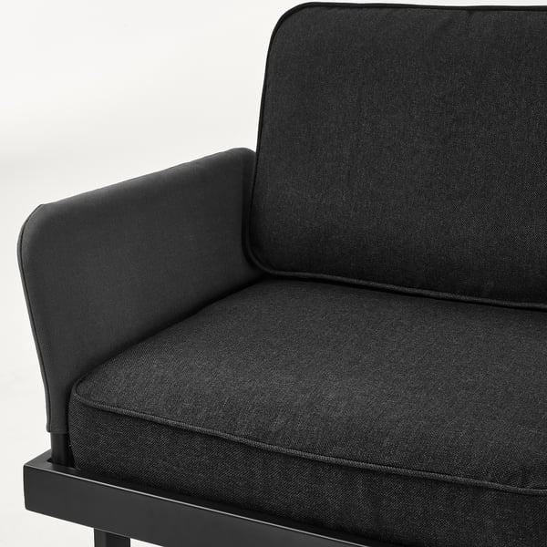 Primer plano de un moderno y cómodo sofá de exterior en tela oscura. Líneas limpias, costuras robustas, representan comodidad de calidad.