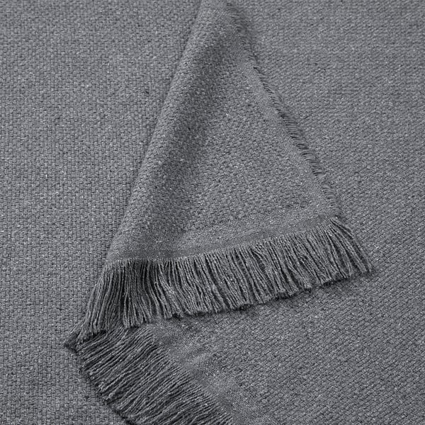 Manta gris suave y texturizada con flecos, drapeada suavemente.