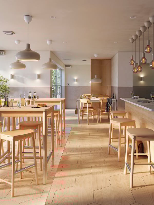 Cafetería moderna con mesas y sillas de madera, iluminación cálida y un diseño minimalista.