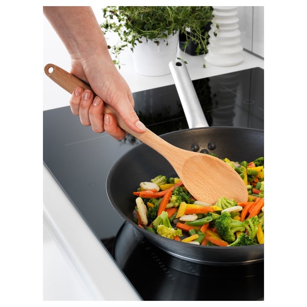 Revolviendo a mano verduras de colores con el utensilio RÖRT en la sartén.