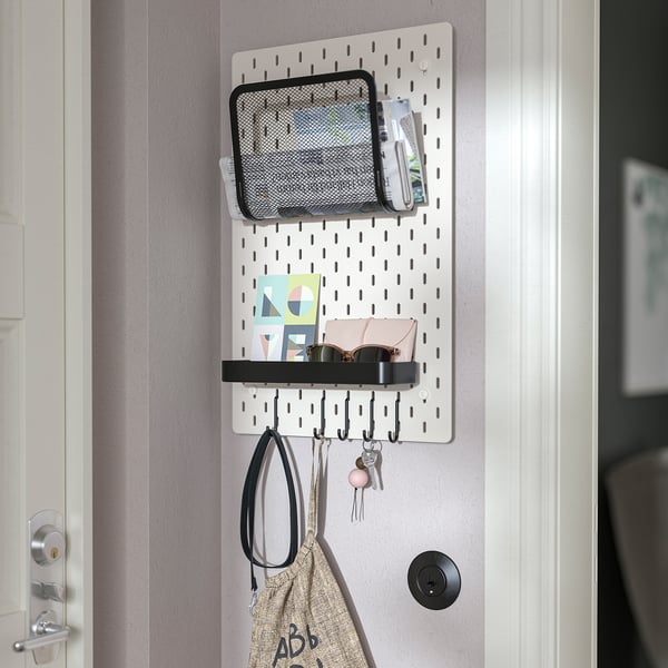 Organizador SKÅDIS de pared con ganchos para colgar, estante y bolsillo de malla para llaves, accesorios y notas.