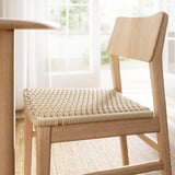 Silla moderna de madera clara con asiento y respaldo con acabado natural, con diseño escandinavo para mayor comodidad y estilo.