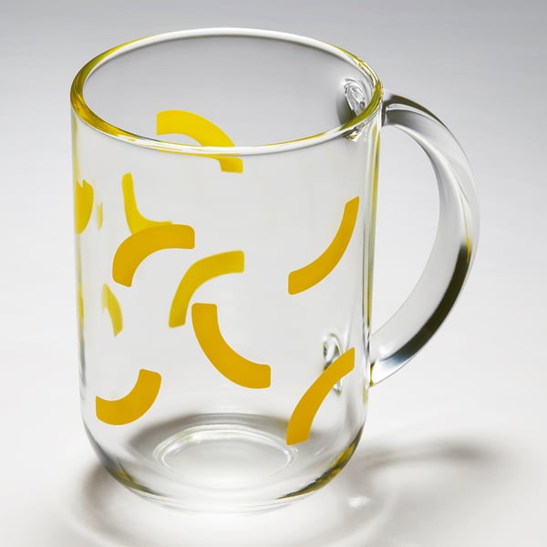 Taza de vidrio transparente con paredes y asa gruesas, decorada con patrones de hojas de color amarillo brillante, con un diseño duradero y elegante.