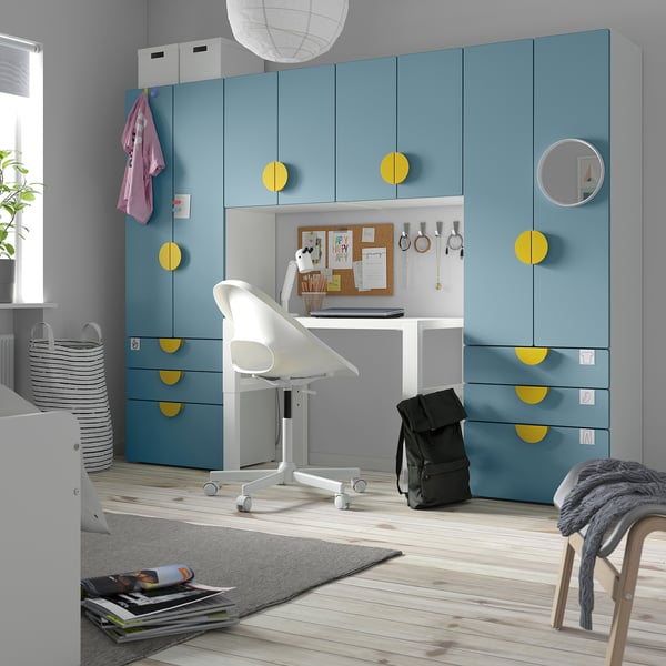 Moderna habitación para niños con armario, escritorio y almacenamiento SMÅSTAD azul y amarillo. Cajones, estantes y una pizarra de corcho.