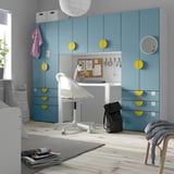 Moderna habitación para niños con armario, escritorio y almacenamiento SMÅSTAD azul y amarillo. Cajones, estantes y una pizarra de corcho.
