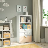 Un mueble de almacenamiento para niños SMÅSTAD blanco con estantes y cajones, que contiene juguetes y suministros en una habitación acogedora y bien iluminada.