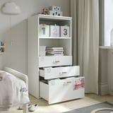 Habitación infantil con estantería SMÅSTAD blanca, donde se guardan juguetes y libros, con varios estantes y cajones para un almacenamiento organizado.