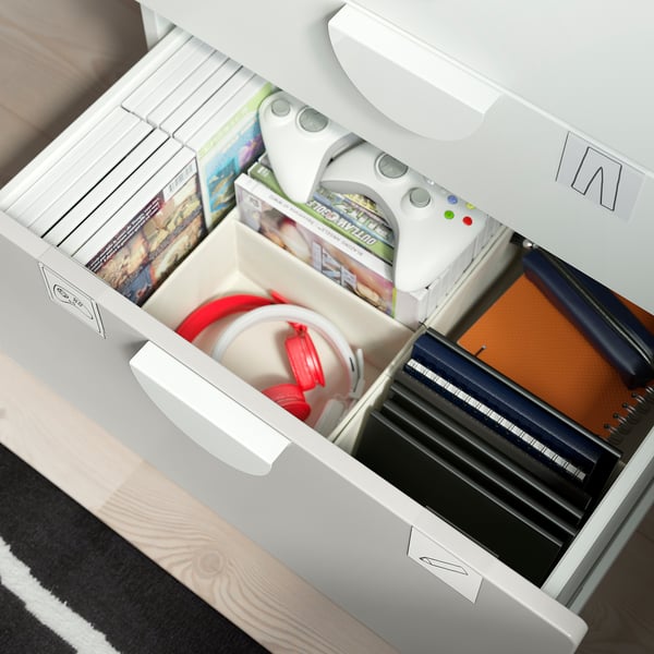 Un mueble de almacenaje SMÅSTAD blanco abierto con cajones y estantes abiertos, que contiene diversos artículos.