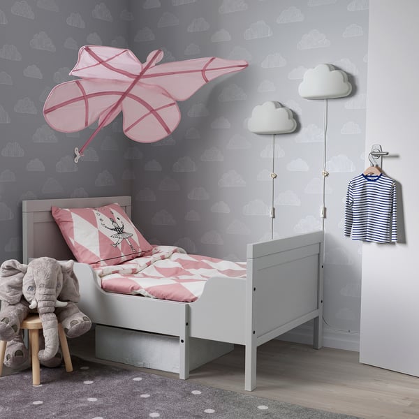 Habitación infantil con paredes de nubes, toldo SNÖFINK, cama gris, juguetes.