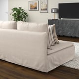 Moderno sofá beige SÖDERHAMN con almohada a rayas, suelo de madera, alfombra blanca, mueble de tv, lámpara y arte de pared.