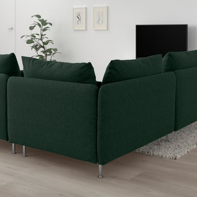 Sofá modular SÖDERHAMN verde oscuro con asientos profundos, colocado contra paredes blancas, junto a una planta y un televisor, sobre un suelo de madera clara.