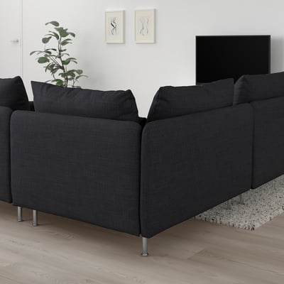 Sofá SÖDERHAMN gris en forma de L en salón minimalista con tv, planta y alfombra.