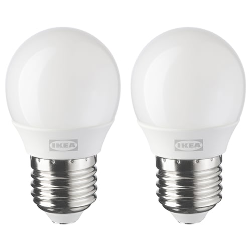 Dos bombillas LED idénticas de ikea, blancas, de forma esférica, colocadas una al lado de la otra.